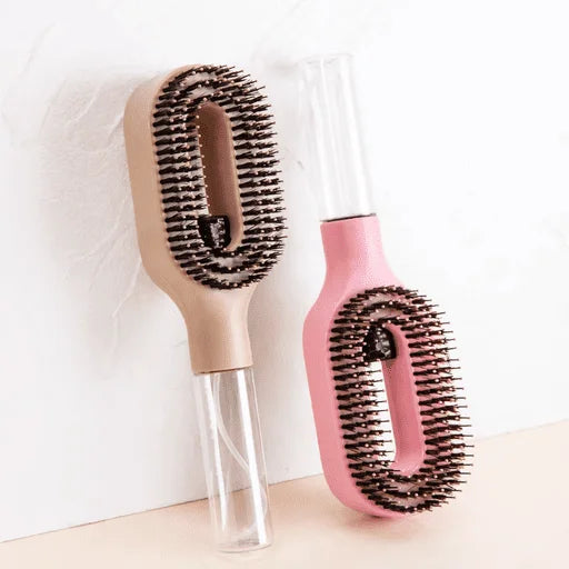 Two hairbrushes, one beige and one pink, on a light background