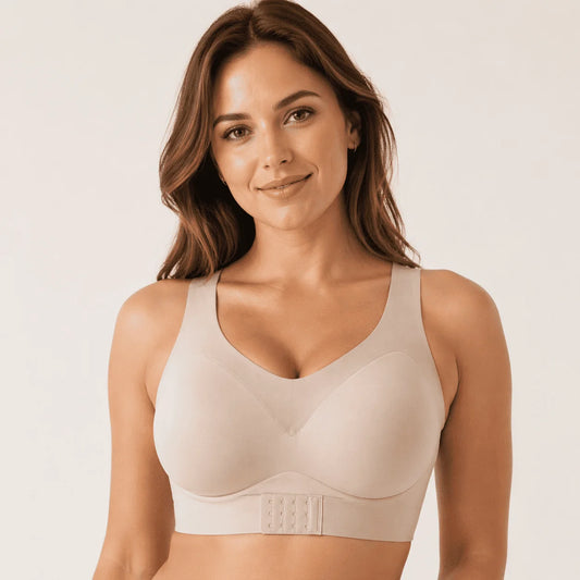 Woman wearing a beige bralette against a plain background