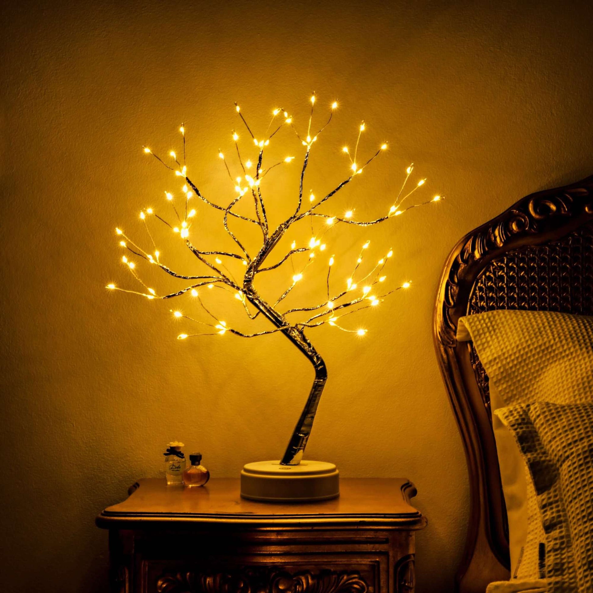 Decorative LED tree on a wooden table with warm lighting