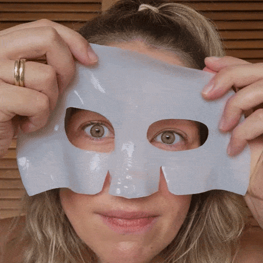 Applying a two-piece hydrogel face mask and smoothing edges.