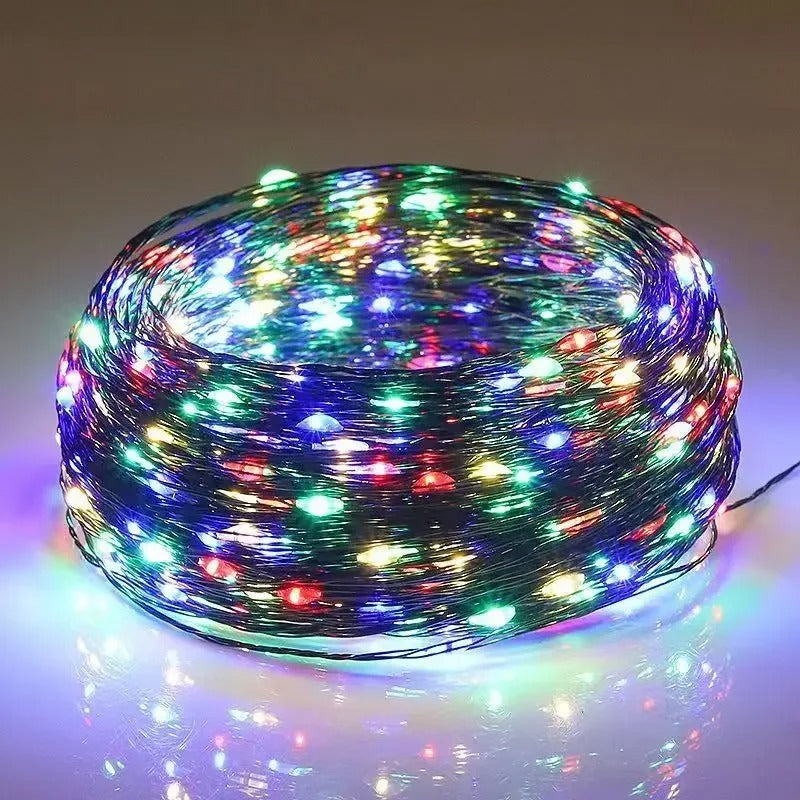 Coiled string of multicolored LED lights on a reflective surface with a neutral background