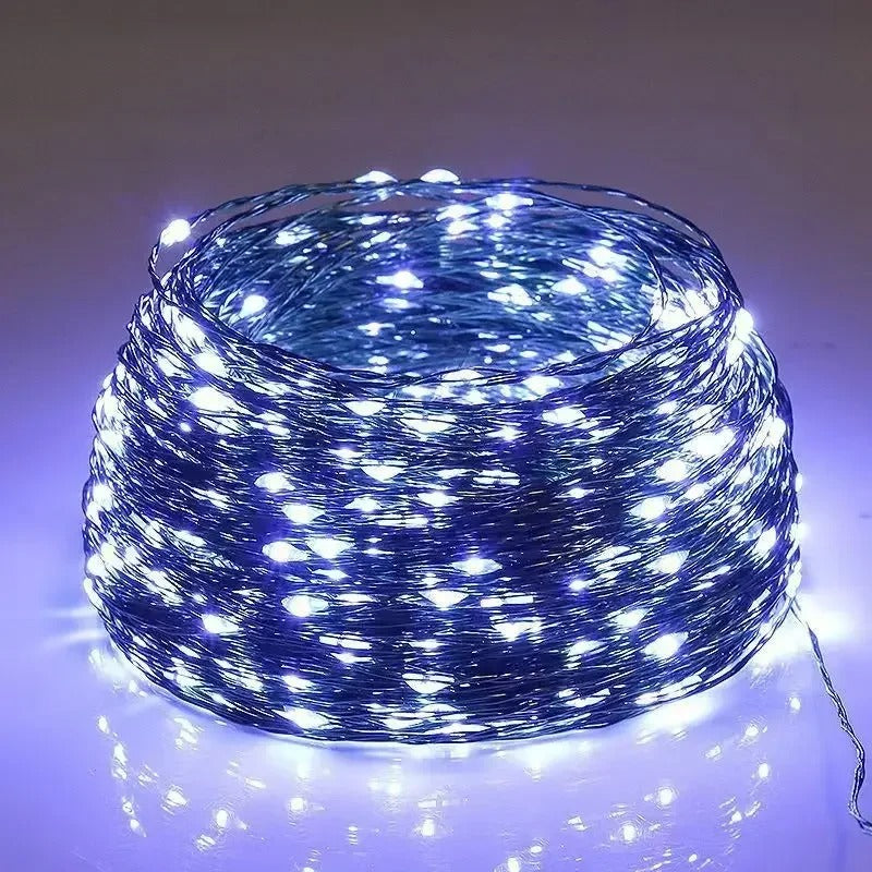 Coiled string of white LED lights on a reflective surface with a neutral background
