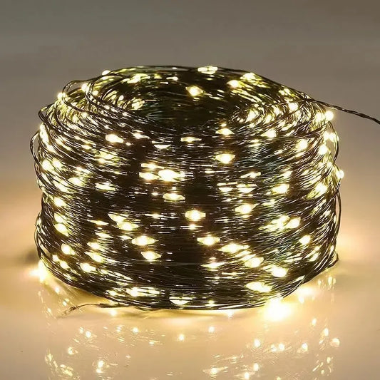 Coiled string of lights with a warm glow on a reflective surface.